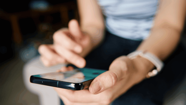 Hands using a smartphone banking app, illustrating Financial Literacy and the use of digital tools for managing personal finances.