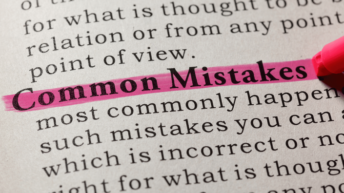 A close-up of a dictionary page with the phrase "Common Mistakes" highlighted in pink. The surrounding text is slightly blurred, emphasizing the highlighted words.