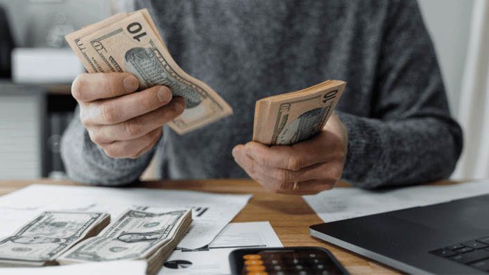 Person saving money to create a 6-12 months emergency fund.
